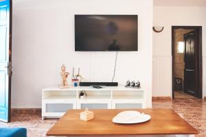 拉桑塔Casa Mar adentro的客厅配有桌子,墙上配有电视