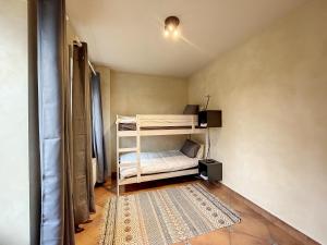Au regard des biches的一间小房间,配有双层床和地毯
