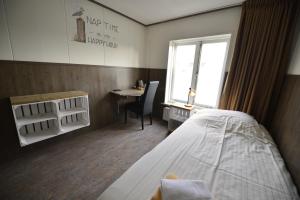 Dinteloord哈文兹科特旅馆的客房设有床、书桌和窗户。