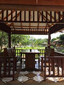 武吉拉旺武吉拉旺托马斯休闲度假旅馆的木制凉亭配有桌椅