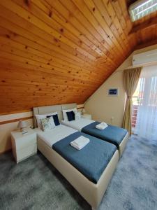 KulaSole Mio Kula的一间卧室设有两张床和木制天花板