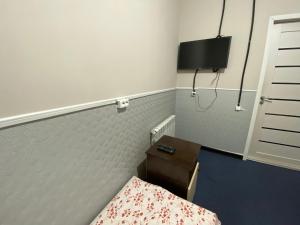阿斯塔纳miniGостиница的一间卧室配有一张床、一张书桌和一台电视。