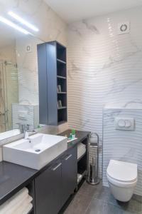 贝尔格莱德Apart Hotel Maksimum的浴室配有白色水槽和卫生间。