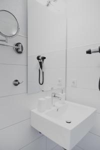 AuenWeingut Hees - Landgasthof Zum Jäger aus Kurpfalz的白色的浴室设有水槽和镜子
