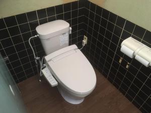 小谷村社森旅馆的浴室铺有黑色瓷砖,设有白色卫生间。