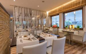 科尔德拉诺Hotel Bamboo的餐厅设有白色的桌椅和窗户。