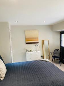 杜伦Contemporary Luxury Barn Conversion in County Durham的一间卧室配有一张床、梳妆台和镜子