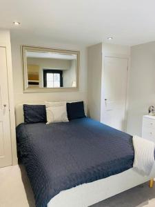 杜伦Contemporary Luxury Barn Conversion in County Durham的一间卧室配有一张带镜子的蓝色床