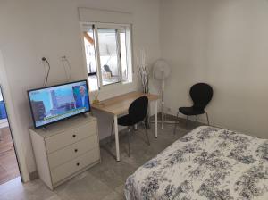 戈梅拉岛圣塞瓦斯蒂安Casita La Gomera的一间卧室配有一张床和一张书桌及电视