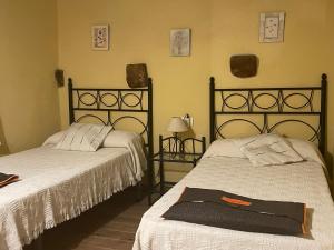 圣马特奥Casa Rural Les Caixes的一间卧室配有两张床和床上的浴袍。