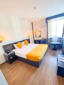 安塔利亚Hotel Güleryüz 2的酒店客房配有一张床铺和一张桌子。