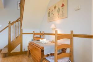 阿尼克Mossyford Cottage的一间设有桌子和两把椅子的房间和一个楼梯