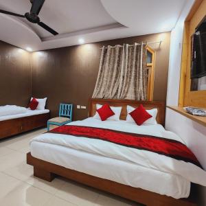 新德里HOTEL ROYAL AFGHAN的一间卧室配有一张带红色枕头的大床