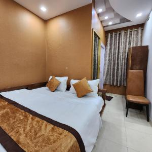 新德里HOTEL ROYAL AFGHAN的一间卧室配有一张大床和一把椅子