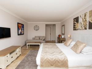 穆然Les chambres d'hôtes de Mougins的卧室配有一张白色的大床和一张沙发。