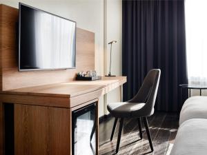 卢森堡拉蒂森卢森堡市公园旅馆的酒店客房设有一张书桌,电视