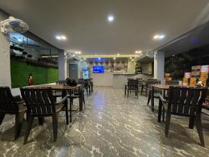 巴加Aariv Inn的一间带桌椅的餐厅和一间酒吧