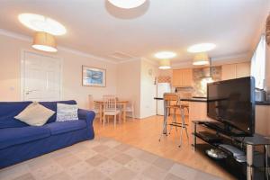 巴姆博格Beachcomber Apartment的一间带蓝色沙发的客厅和一间厨房