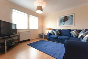 巴姆博格Beachcomber Apartment的客厅配有蓝色的沙发和电视