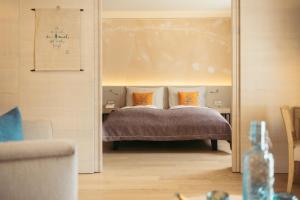 魏森湖Strandhotel am Weissensee的一间卧室配有带橙色枕头的床