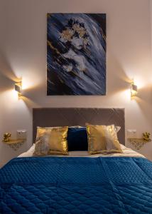 霍茹夫Apartamenty Yeti & Wilka w Centrum Chorzowa - Yeti的一间卧室配有一张蓝色的床,上面有绘画作品