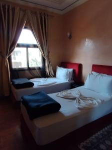 泰赫瑙特ApartHotel Nzaha的带窗户的客房内的两张床