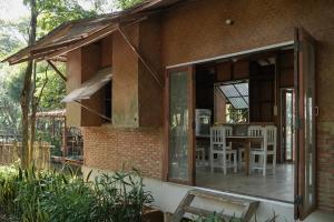 清道Art House at Chiangdao - Waterlily House的砖屋,设有门廊和桌椅
