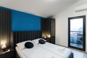 梅杜林Boutique Suites Joyce Medulin with free parking的一间卧室配有一张白色大床和蓝色的墙壁
