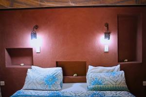 利文斯顿姆伽生态小屋的一间卧室配有两张床,墙上有两盏灯