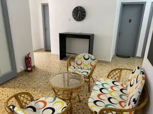阿吉亚特拉萨Sunset view Rooms的客厅配有椅子、桌子和壁炉