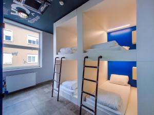萨格勒布中央广场旅舍的双层床间 - 带三张双层床和一扇窗户