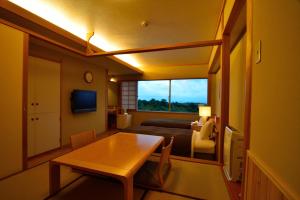 南小国町Senomoto Kogen Hotel的客房设有桌子、床和窗户。