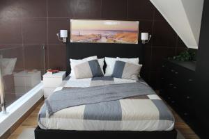 萨卡文Terreirinho 1 e 2的卧室配有一张床,墙上挂有绘画作品