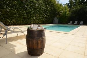 Bresse-sur-GrosneGite Le Foineau - Maison avec Piscine的坐在游泳池旁的木桶