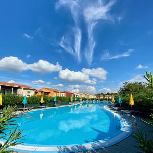 卡斯特努沃德加尔达贝维德雷乡村酒店的一个带椅子和遮阳伞的大型游泳池