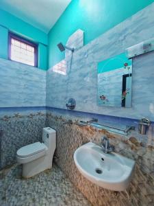 拉明德Tathāgata Homestay的一间带水槽、卫生间和镜子的浴室
