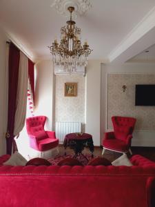 第比利斯Old Tbilisi Apartment的客厅配有红色的沙发和两把椅子