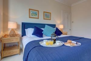 亨斯坦顿Fabulous Seaside Retreat的蓝色的床,上面有盘子的食物