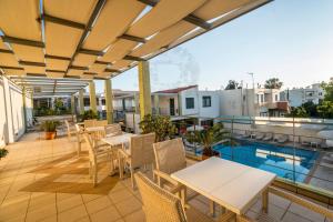 加藤-达拉特索雅典娜海滩酒店的一个带桌椅的阳台和一个游泳池