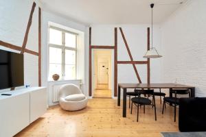 哥本哈根Scandinavian Style 3BR in Copenhagen City Centre的客厅配有桌椅和电视。