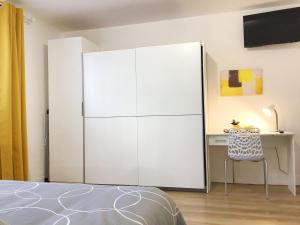 卢尔德Appartements Sun, parking, centre ville , proche Sanctuaires的卧室里一张大白色的橱柜,配有书桌