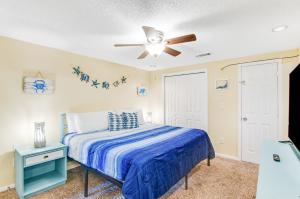 泰比岛Tybee Southern Comfort的一间卧室配有一张床和吊扇