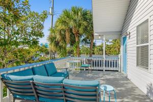 泰比岛Tybee Southern Comfort的一个带蓝色椅子和桌子的庭院,并种植了棕榈树