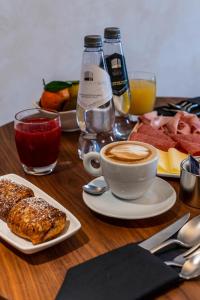 罗马加斯米特城市套房公寓式酒店的餐桌,茶几,咖啡和一盘食物