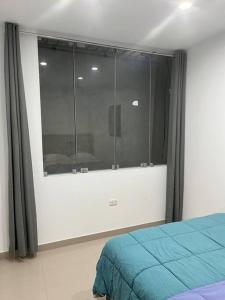 伊察Apartamento en Ica 3的一间卧室设有一张床和一个大窗户