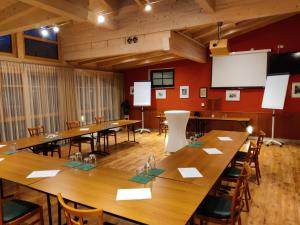 Wernstein am InnLandhotel Mariensäule的大型会议室配有木桌和椅子