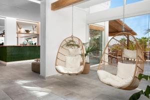 马萨鲁布朗斯Maya Beach Resort的带餐厅的房间设有两张秋千椅