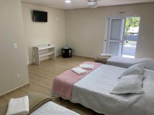 阿瓜斯迪林多亚Pousada Saint James的一间卧室配有两张床和电视。