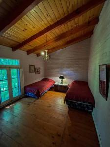 波特雷里约斯Casa de montaña en un lugar mágico的一间卧室设有两张床和木制天花板
