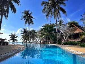 沙拉海滩Green Papaya Beach Resort, Koh Phangan的棕榈树海滩旁的游泳池